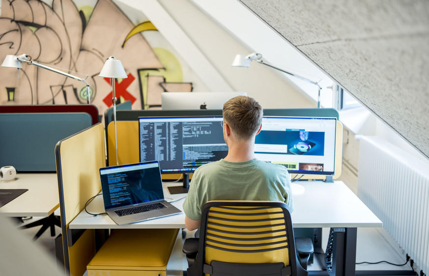 Coworker arbeitet an Schreibtisch am Arbeitsplatz im Coworking Space Coworker im SteamWork